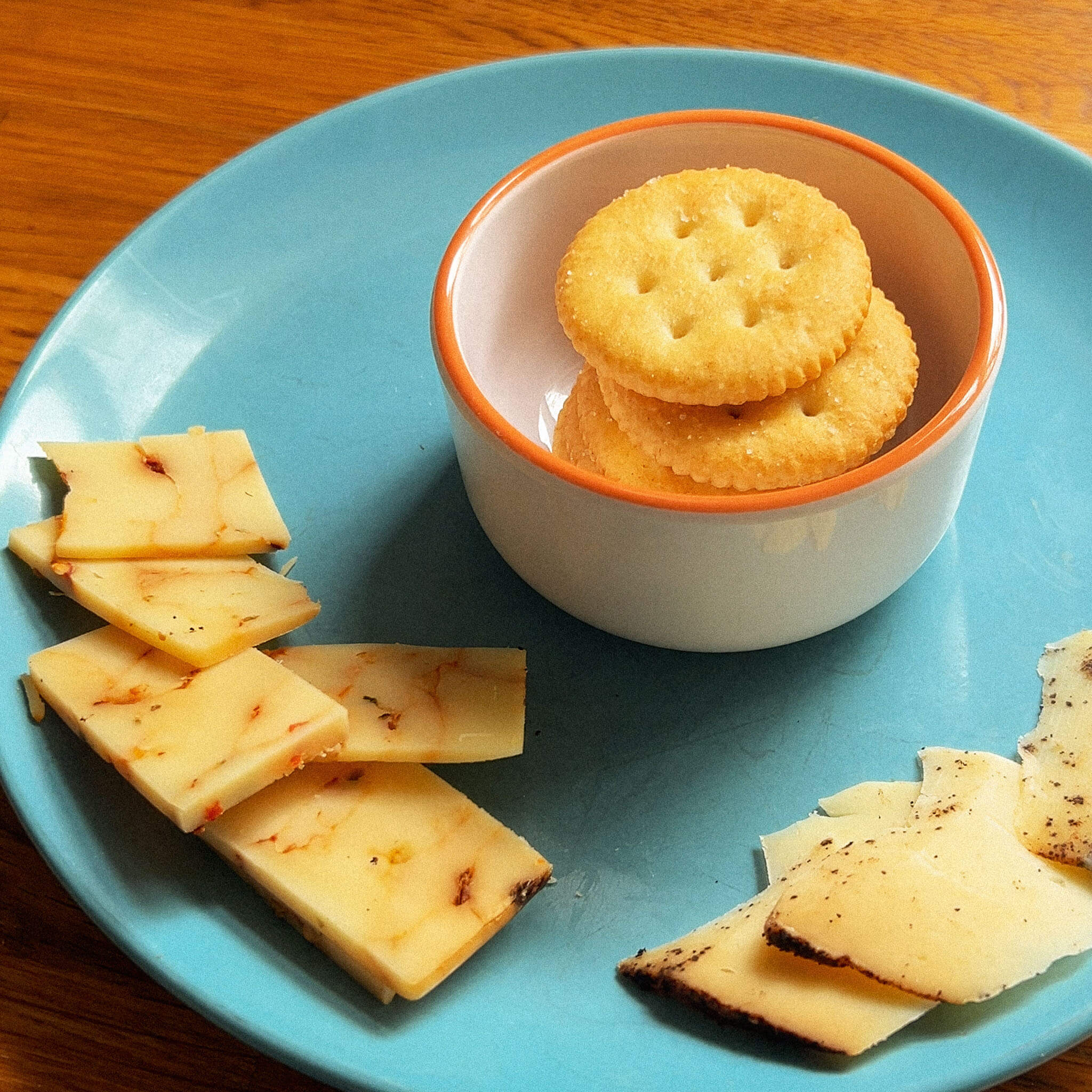 Ritz crackers and cut up pieces of spicy cheddar cheese and a lavender coffee cheese.