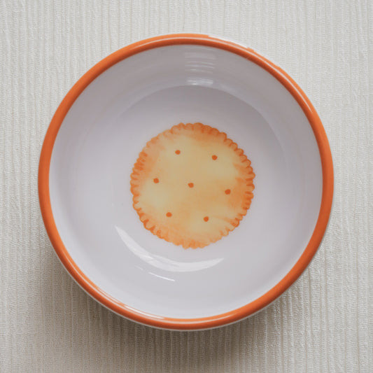 Looking down on the crackers Macro Bowl, showing a colorful illustration of a golden round cracker on the bottom of the bowl.