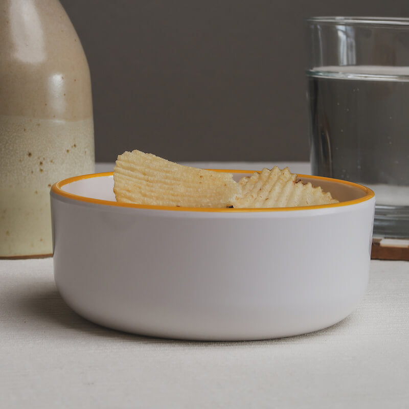 A side view of the chips Macro Bowl being filled to the rim with potato chips.