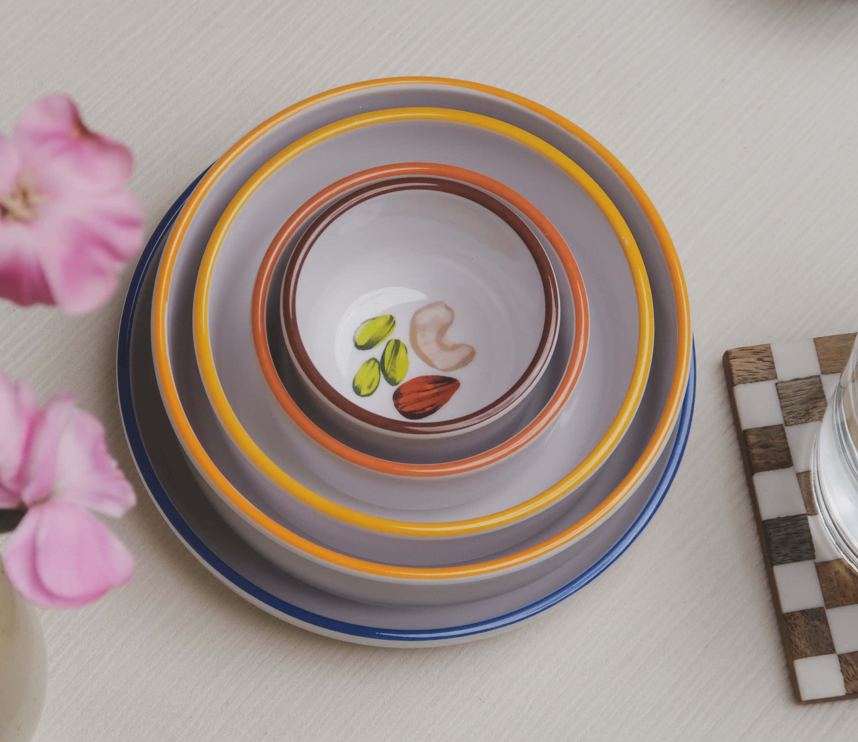 All 5 macro bowls being nested into one another, with flowers and a drink coaster visible to the sides.